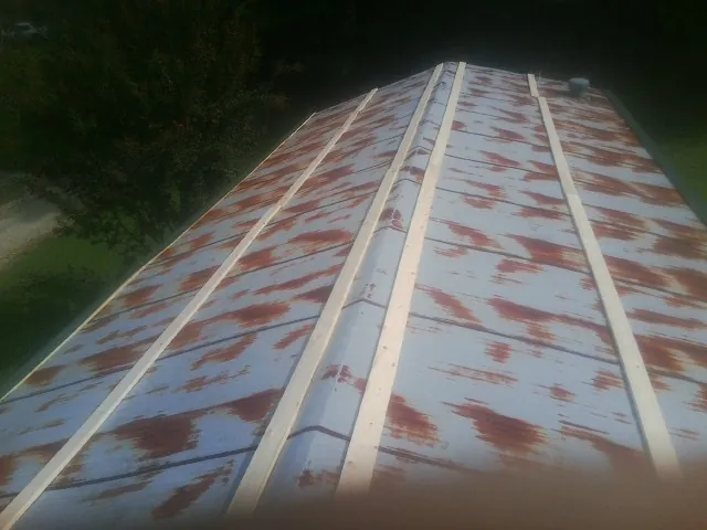 Rusted metal roof panels with new wood purlins before replacement — Storm Damage Roof Repair in Chicago Heights by Roofing Brothers