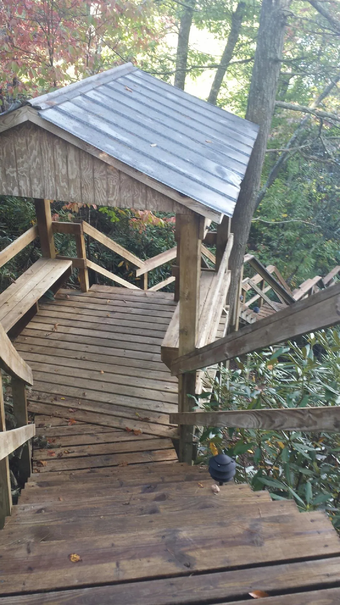 Metal roofed shelter over wooden steps on a wooded walkway — Skylight Repair & Installation work by our crew in Chicago Heights