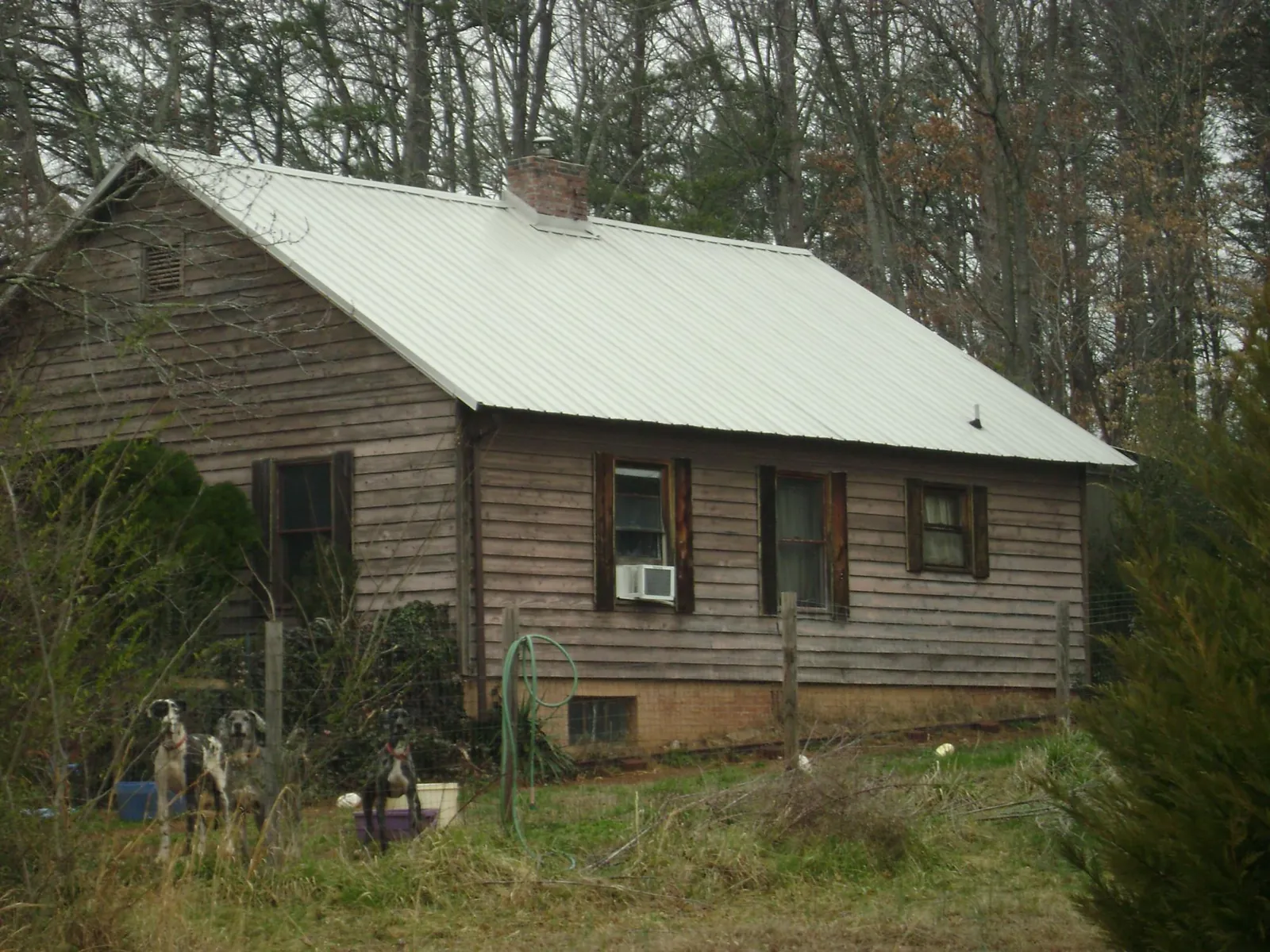 White metal roof on an old wood sided farmhouse, from a Metal Roof Installation job in Chicago Heights